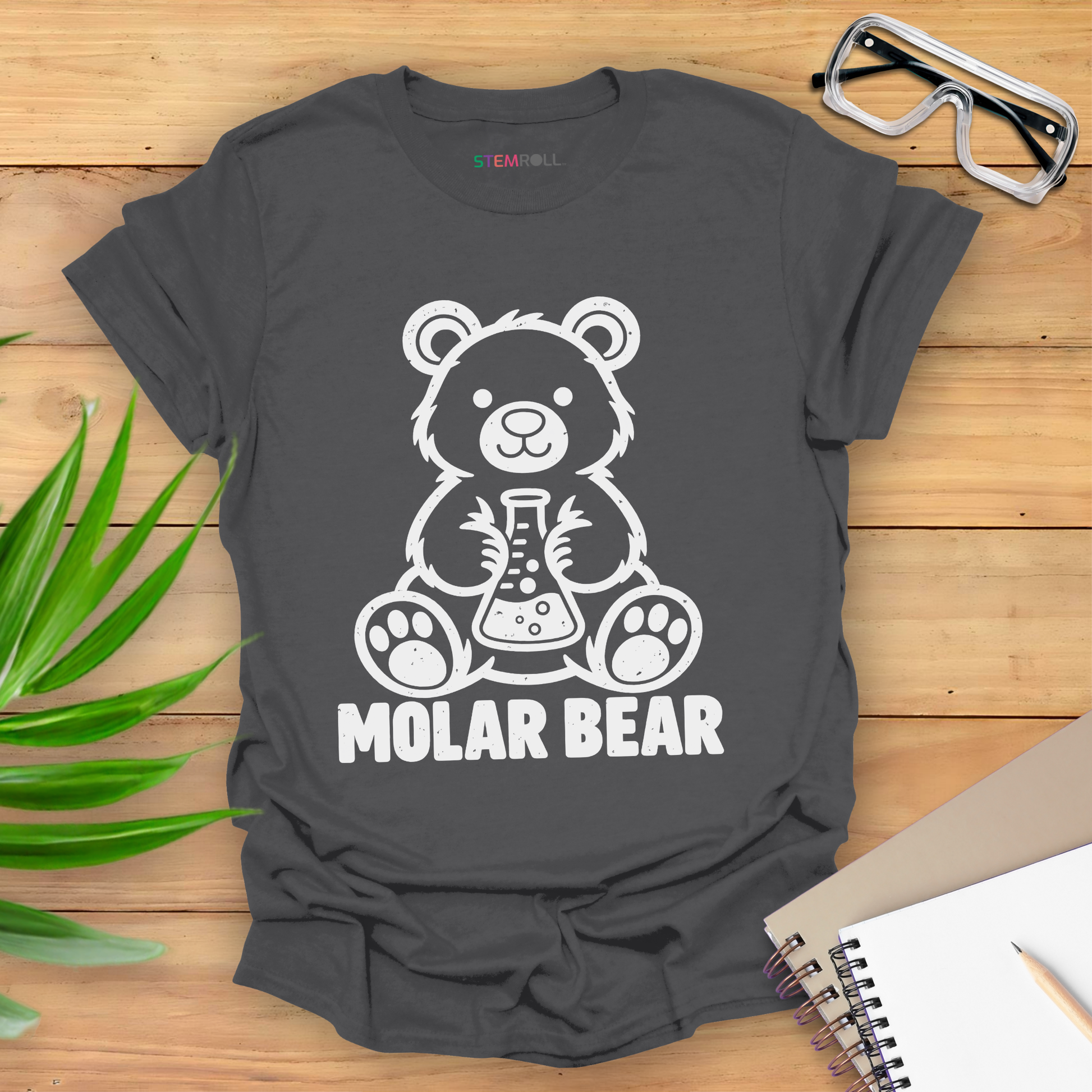 Molar Bear chemistry t-shirt in charcoal, flat lay with safety goggles and notebook