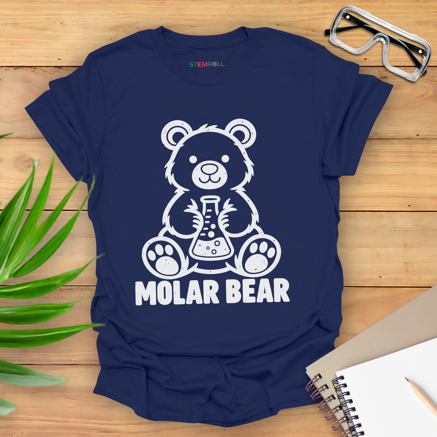 Molar Bear chemistry t-shirt in navy, flat lay with safety goggles and notebook