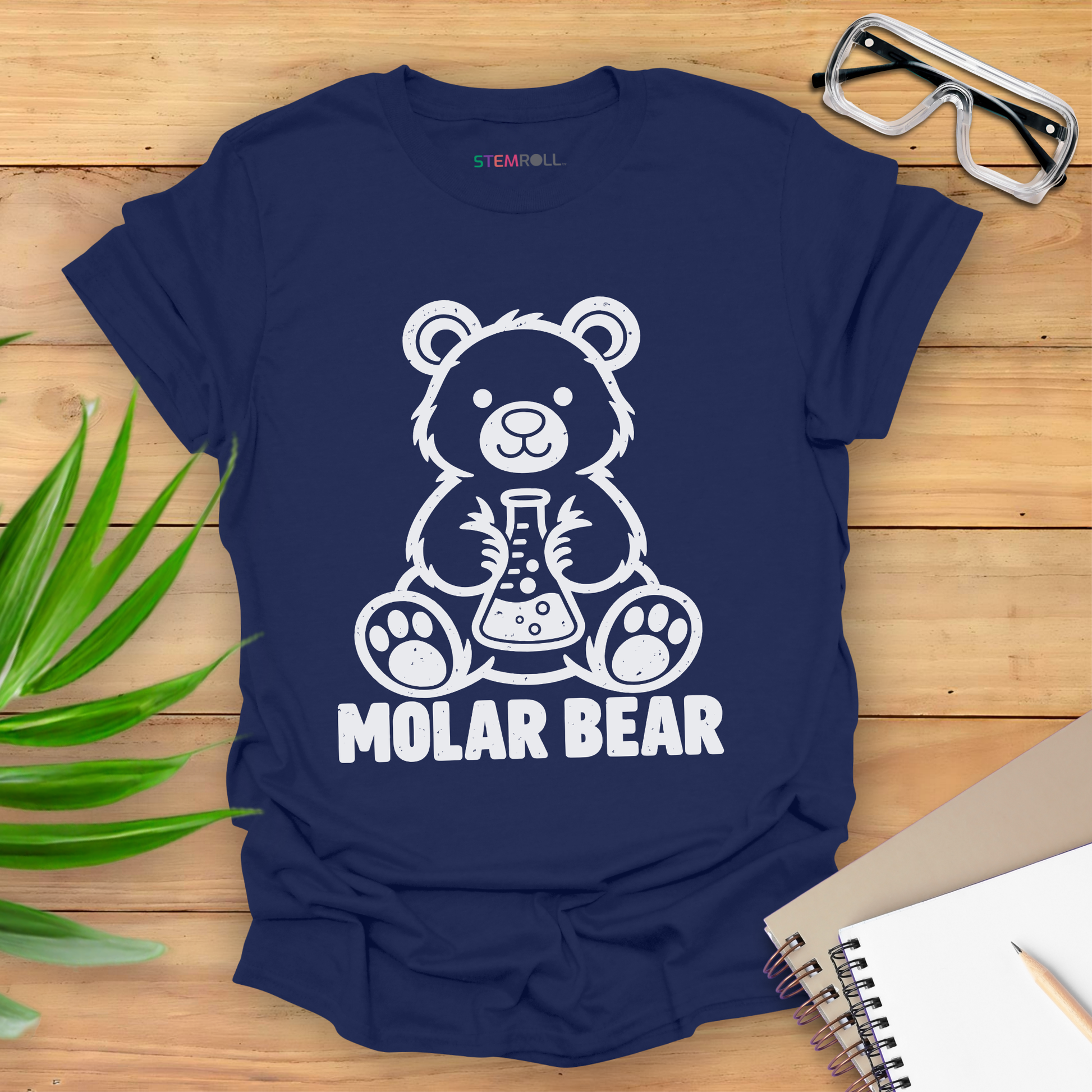 Molar Bear chemistry t-shirt in navy, flat lay with safety goggles and notebook